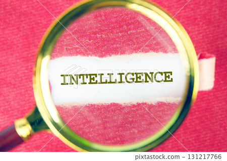 INTELLIGENCE word was found using a magnifying glass under a piece of paper. Translation technology concept 131217766