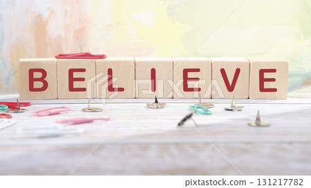 The concept word BELIEVE is made of wooden cubes on an abstract background. Business believe concept. Copy space The concept word BELIEVE is made of wooden cubes on an abstract background. Business believe concept. Copy space 131217782