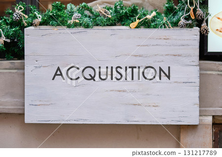Corporate acquisition and merger concept. Copy space. ACQUISITION text written on A blank wooden sign Corporate acquisition and merger concept. Copy space. ACQUISITION text written on A blank wooden sign 131217789
