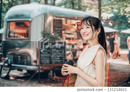 Young woman enjoying food and drinks at outdoor marketplace Young woman enjoying food and drinks at outdoor marketplace 131218021