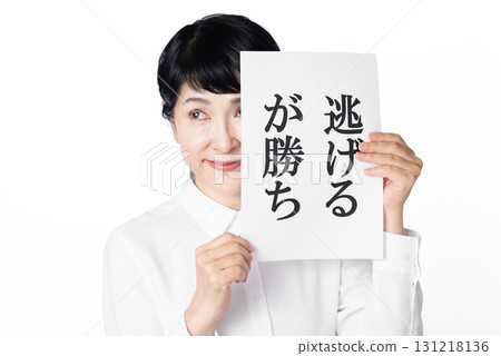 A senior woman grinning while holding a piece of paper that says "Run away to win" 131218136