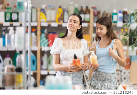 Woman with preteen daughter choosing liquid soap in store Woman with preteen daughter choosing liquid soap in store 131218245