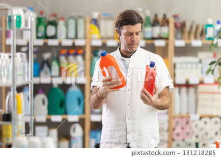 Man choose product and doubts, faultfinding buyer pick sewer cleaner liquid for allergy sufferers Man choose product and doubts, faultfinding buyer pick sewer cleaner liquid for allergy sufferers 131218285