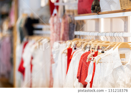 View of clothing boutique hall with clothes on hangers View of clothing boutique hall with clothes on hangers 131218376