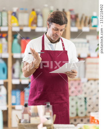 Anxious man seller with checklist in decorated store Anxious man seller with checklist in decorated store 131218402