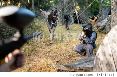 Impudent teams facing on battlefield in outdoor paintball arena during match 131218541