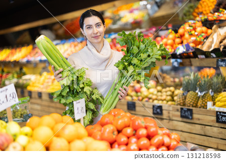 Woman choosing celery in the store 131218598