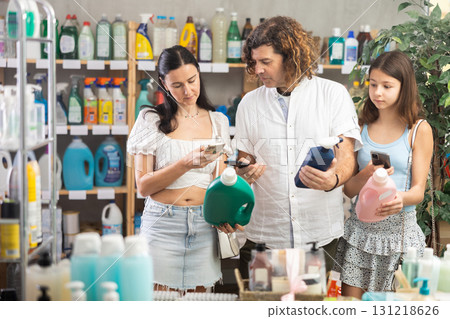 Family scanning QR-code on detergent and spray in store 131218626