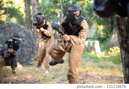 Team of paintball players attacks enemy at an army training ground Team of paintball players attacks enemy at an army training ground 131218676