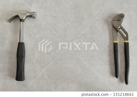Tools on a mortar background: Hammer and pliers Tools on a mortar background: Hammer and pliers 131218681