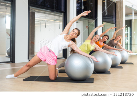 Pilates women fitball side bend exercise workout at gym 131218720