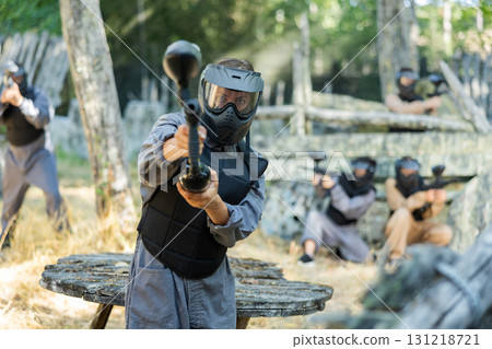 Woman targeting and shooting with paintball gun 131218721