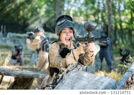 Woman fires a gun with passion while playing paintball 131218751
