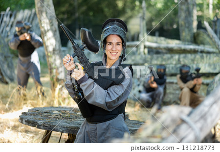 Portrait of happy woman in paintball equipment 131218773