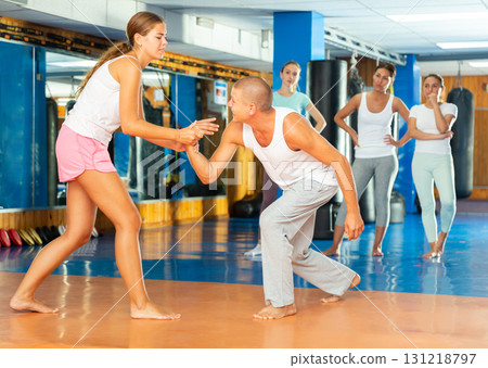 Young woman practicing self defence techniques with coach Young woman practicing self defence techniques with coach 131218797