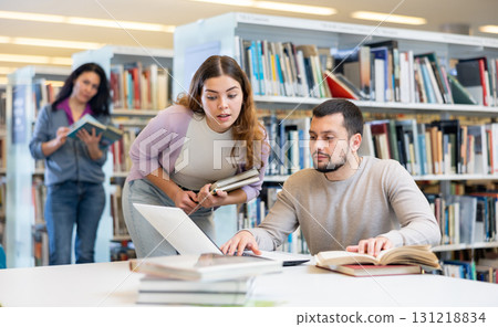 Woman and man studying together at library Woman and man studying together at library 131218834
