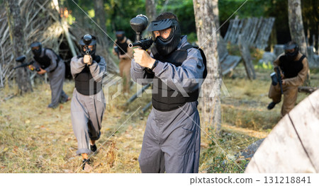 Impudent teams facing on battlefield in outdoor paintball arena during match Impudent teams facing on battlefield in outdoor paintball arena during match 131218841
