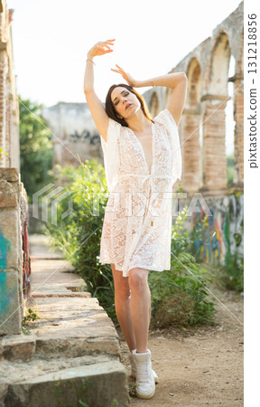 Adult woman in lace robe posing in garden Adult woman in lace robe posing in garden 131218856