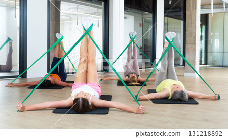 Women doing pilates exercise with expander tape Women doing pilates exercise with expander tape 131218892