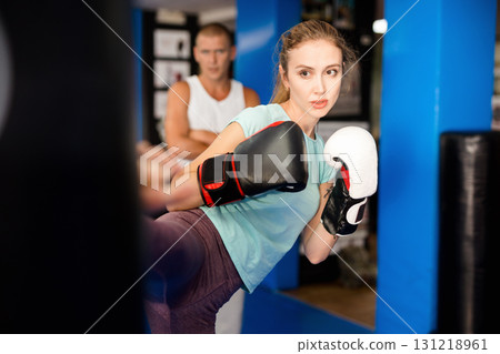 Woman kicking punchbag 131218961