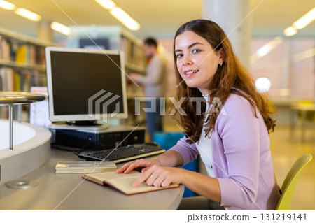 Young woman working with book and computer 131219141