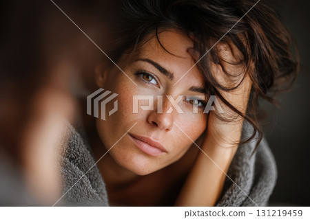 Young woman reflecting on burnout in soft lighting 131219459