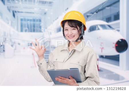 A female worker performing maintenance and inspection of an airplane A female worker performing maintenance and inspection of an airplane 131219828