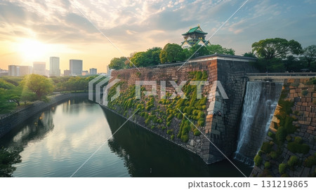 Scenic View of Historic Castle and Serene Waterfall at Sunset 131219865