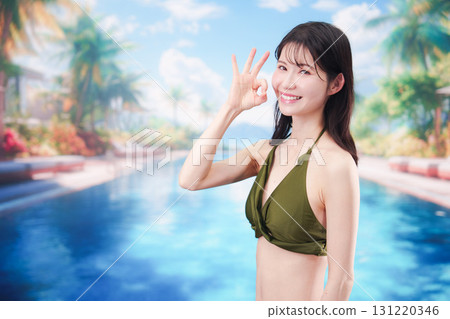 Young woman enjoying summer at resort pool 131220346