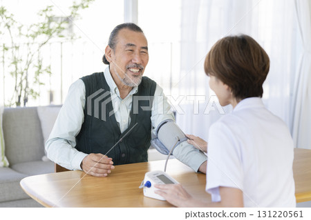 Senior man having his blood pressure measured by medical staff Senior man having his blood pressure measured by medical staff 131220561