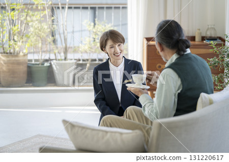Facility staff talking to senior man 131220617