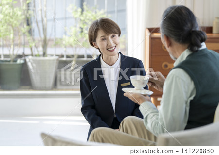 一位資深女性機構工作人員正在與一位老人交談 一位資深女性機構工作人員正在與一位老人交談 131220830