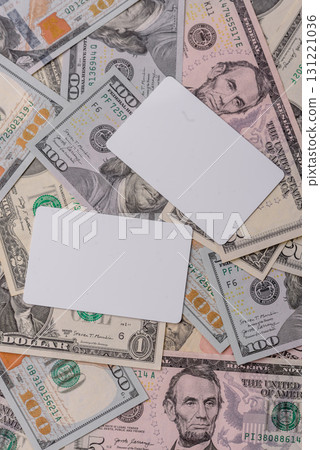 The white plastic card as a symbol of cashless payments on the background of cash paper money of USA The white plastic card as a symbol of cashless payments on the background of cash paper money of USA 131221036