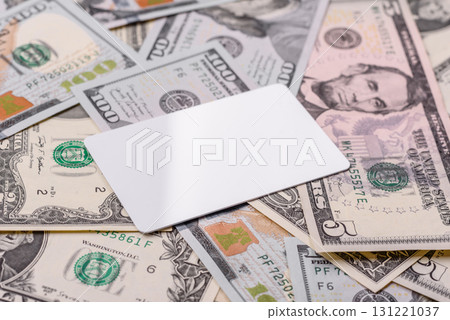 The white plastic card as a symbol of cashless payments on the background of cash paper money of USA The white plastic card as a symbol of cashless payments on the background of cash paper money of USA 131221037