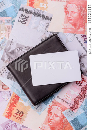 The white plastic card as a symbol of cashless payments on the background of cash paper money of Brazil The white plastic card as a symbol of cashless payments on the background of cash paper money of Brazil 131221113