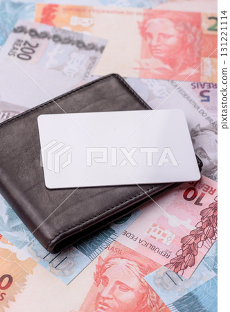 The white plastic card as a symbol of cashless payments on the background of cash paper money of Brazil The white plastic card as a symbol of cashless payments on the background of cash paper money of Brazil 131221114