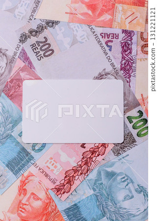 The white plastic card as a symbol of cashless payments on the background of cash paper money of Brazil The white plastic card as a symbol of cashless payments on the background of cash paper money of Brazil 131221121