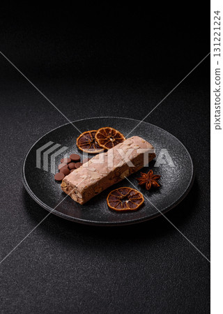 Nougat or white caramel with hazelnuts and pistachios and citrus pieces. White nougat with nuts 131221224