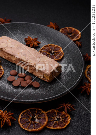 Nougat or white caramel with hazelnuts and pistachios and citrus pieces. White nougat with nuts 131221232