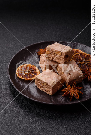 Nougat or white caramel with hazelnuts and pistachios and citrus pieces. White nougat with nuts Nougat or white caramel with hazelnuts and pistachios and citrus pieces. White nougat with nuts 131221263