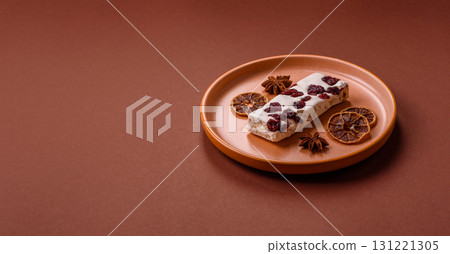 Nougat or white caramel with hazelnuts and pistachios and citrus pieces. White nougat with nuts 131221305