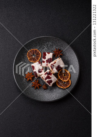 Nougat or white caramel with hazelnuts and pistachios and citrus pieces. White nougat with nuts 131221322