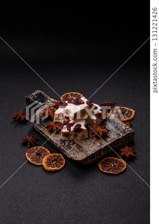 Nougat or white caramel with hazelnuts and pistachios and citrus pieces. White nougat with nuts 131221426