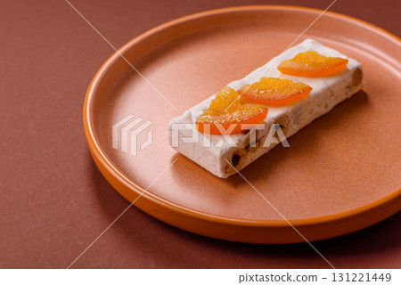 Nougat or white caramel with hazelnuts and pistachios and citrus pieces. White nougat with nuts 131221449