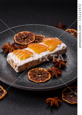 Nougat or white caramel with hazelnuts and pistachios and citrus pieces. White nougat with nuts 131221472