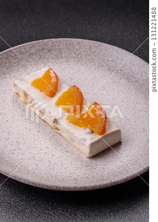 Nougat or white caramel with hazelnuts and pistachios and citrus pieces. White nougat with nuts 131221488