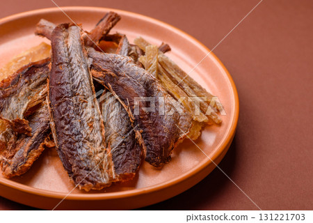 Dried salted fish as snacks or jerky, seafood as slices. Dried seafood snacks 131221703