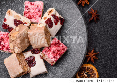 Nougat or white caramel with hazelnuts and pistachios and strawberry pieces. Nougat with nuts Nougat or white caramel with hazelnuts and pistachios and strawberry pieces. Nougat with nuts 131222178