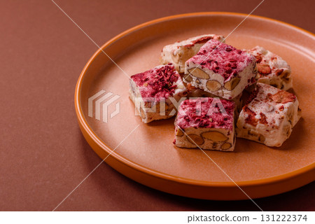 Nougat or white caramel with hazelnuts and strawberry pieces. White nougat 131222374