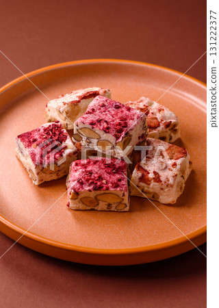 Nougat or white caramel with hazelnuts and strawberry pieces. White nougat 131222377